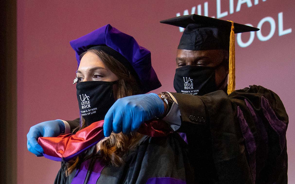 William H. Bowen Law School graduates participate in a hooding ceremony during the fall 2020 commencement. 
